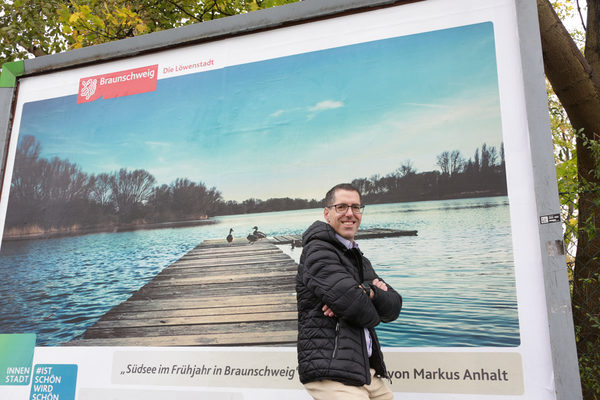 Fotowettbewerb „#braunschweigistschön“ der Citymarketingkampagne „Ist schön. Wird schön“: Markus Anhalt vor seinem Gewinnermotiv „Südsee im Frühjahr in Braunschweig“ auf einer 3,5 m mal 2,5 m großen Plakatwand. (Wird bei Klick vergrößert)