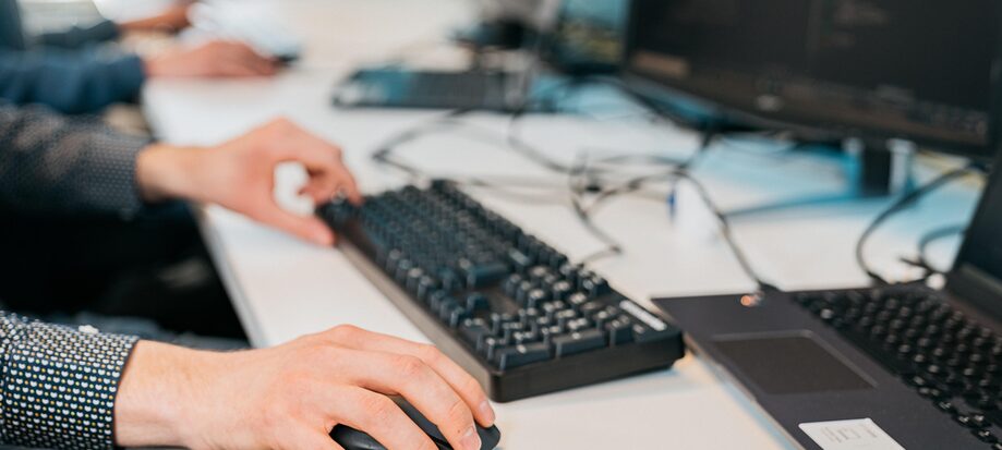 Hand auf einer Maus, Tastatur, Notebook