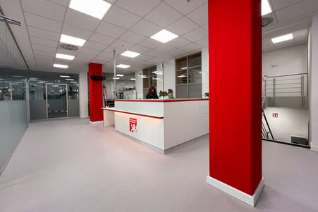 Büro mit roten Säulen und weißer Bürotheke