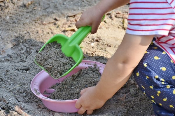 Ein Kind spielt im Sand (Wird bei Klick vergrößert)