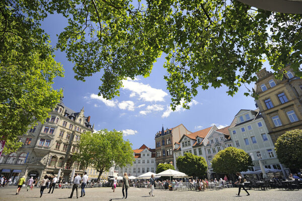 Das Bild zeigt den Kohlmarkt in Braunschweig mit Passanten. Am oberen Rand sind die grünen Blätter von Bäumen zu sehen. (Wird bei Klick vergrößert)